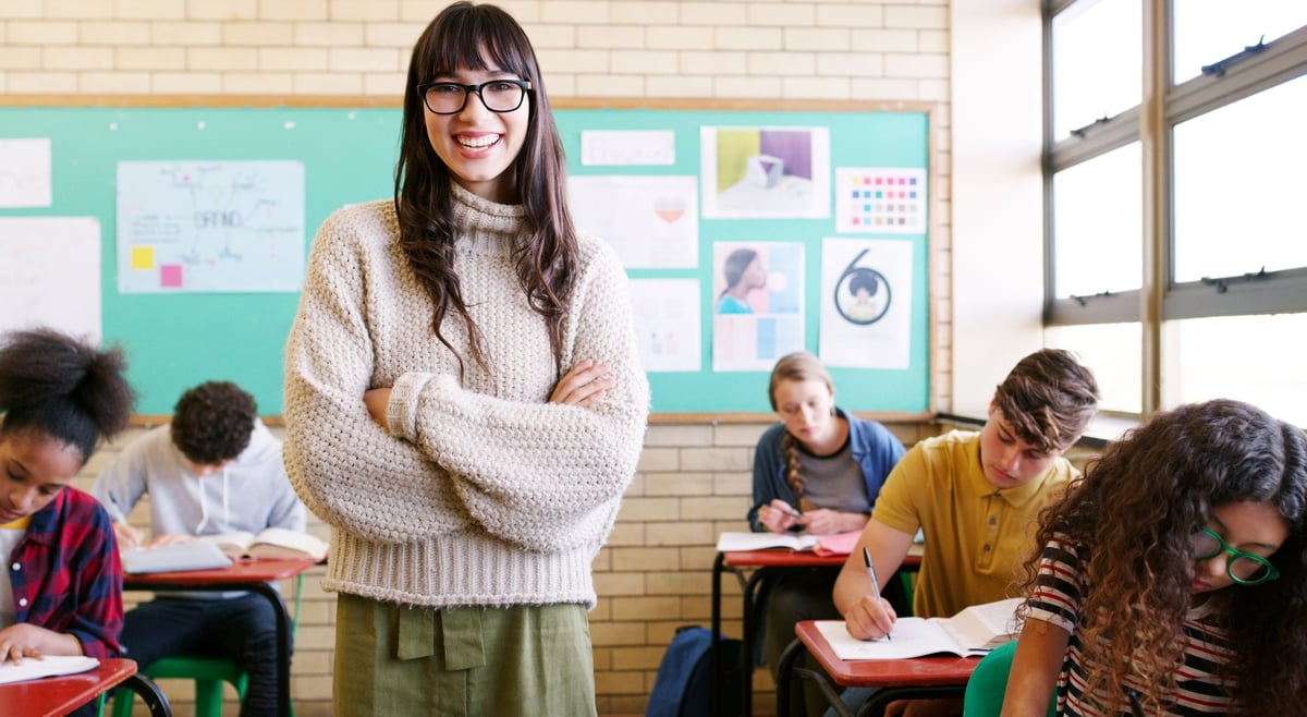 A cheerful teacher giving a class to a group of students during the school day