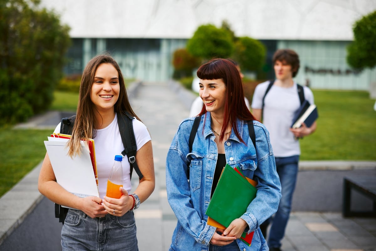 Two university students walking and talking on campus