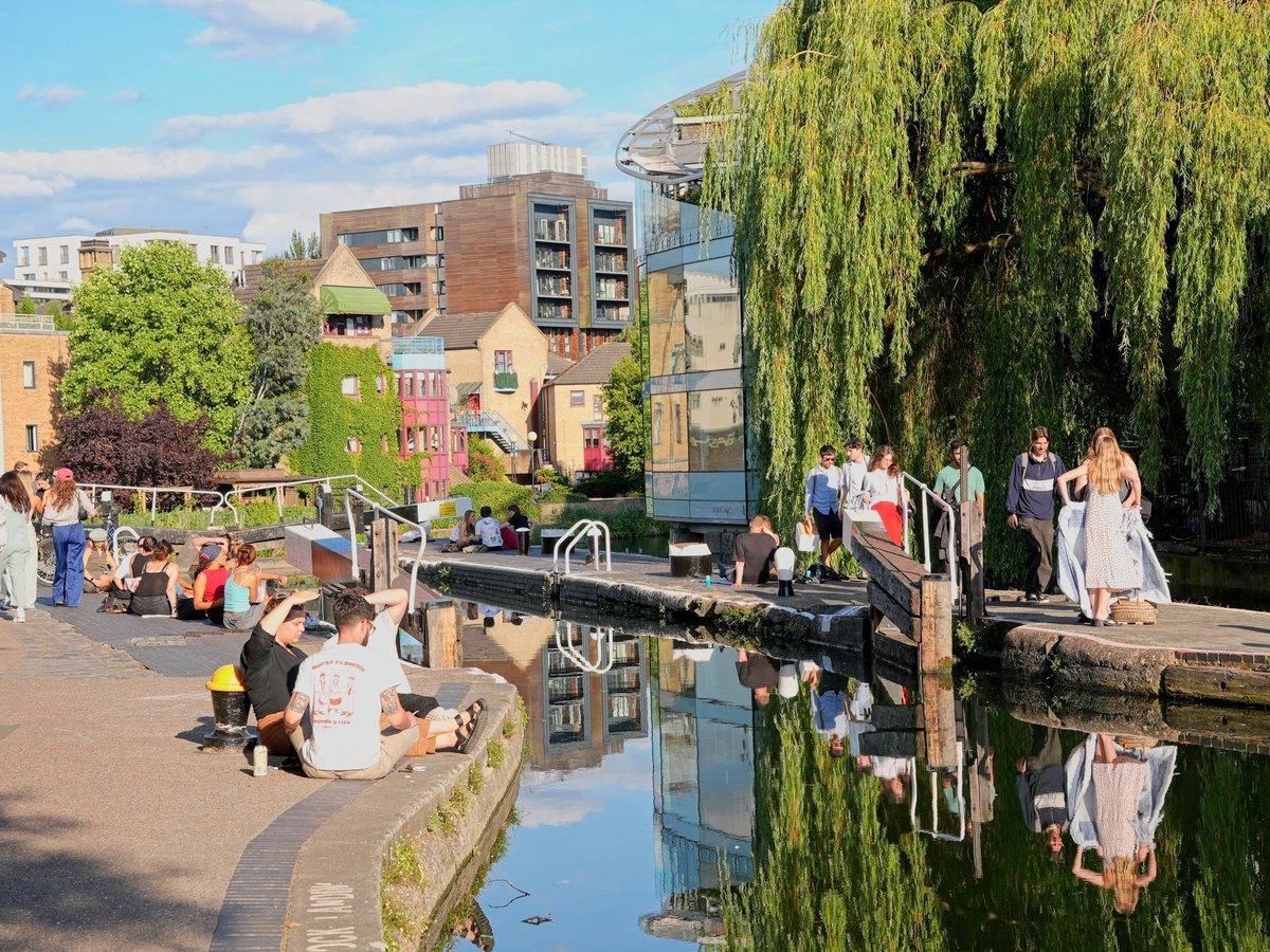 A canal lined with boats and trees in a British city