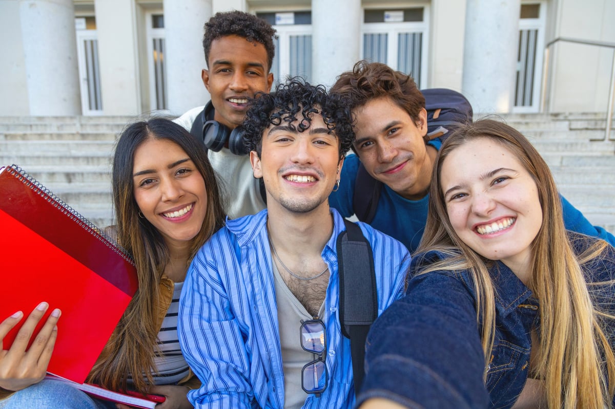 Students on a campus, smiling together for a photo at a summer camp