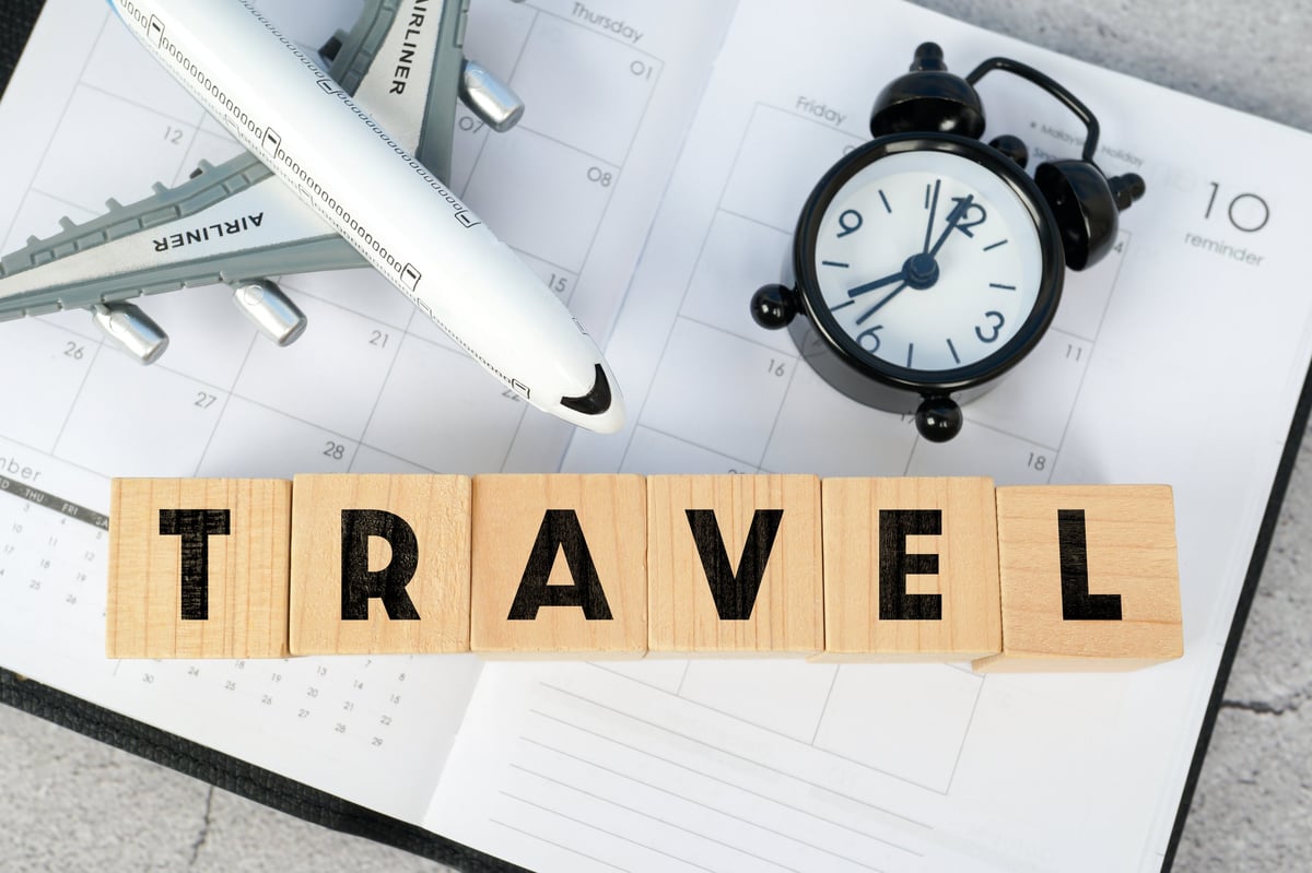 Travel planning items with a small airplane, notebook and planner